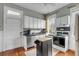 Functional kitchen boasts white cabinets, stainless steel appliances, and wooden floors at 318 Sumter St, Charleston, SC 29403