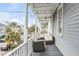 Inviting porch with comfortable outdoor seating, white columns, and views of the street at 318 Sumter St, Charleston, SC 29403