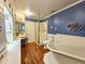 This bathroom showcases a standalone tub, shower, and vanity with blue accent wall at 1003 Wichman St, Walterboro, SC 29488