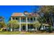 Charming two-story home with a spacious front porch, classic columns, lovely shutters and flowering trees at 1003 Wichman St, Walterboro, SC 29488