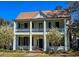 Charming two-story home with a spacious front porch, classic columns, lovely shutters and young trees at 1003 Wichman St, Walterboro, SC 29488