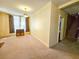 Living room featuring neutral walls, vintage curtains, and doorway leading to carpeted stairs at 1003 Wichman St, Walterboro, SC 29488