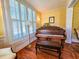Charming piano room with hardwood floors, a vintage piano, and bright natural light from shuttered windows at 1003 Wichman St, Walterboro, SC 29488