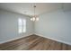 Open dining room featuring new floors, modern chandelier and shuttered window at 102 Challis Ct, Goose Creek, SC 29445