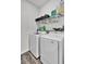 Convenient laundry room with modern washer and dryer units, shelving, and hardwood floors at 1032 Berry Patch Cir, Summerville, SC 29485