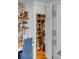 Pantry and shelving sit adjacently to kitchen desk area with white cabinetry and brick accent wall at 106 Queen St # B, Charleston, SC 29401