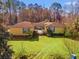 Aerial view showcasing a charming yellow home with green shutters and a well-manicured front lawn at 1117 Walleye Rd, Bonneau, SC 29431