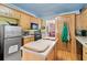 Efficient kitchen features stainless steel refrigerator, black appliances, and functional island at 1117 Walleye Rd, Bonneau, SC 29431