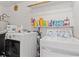 Bright laundry room with modern washer and dryer units and shelving at 1117 Walleye Rd, Bonneau, SC 29431