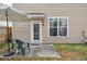 Back patio with a door and window, complemented by outdoor seating and a striped umbrella for shade at 120 Diploma Dr, Ladson, SC 29456