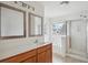 Bright bathroom with a double mirror, wood vanity, bathtub, and glass shower at 120 Diploma Dr, Ladson, SC 29456