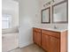 Bathroom showcasing a wood vanity, neutral tile, and views into another room at 120 Diploma Dr, Ladson, SC 29456