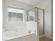 Bathroom featuring a tiled shower and a large bathtub beneath a window at 120 Diploma Dr, Ladson, SC 29456