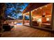 Expansive covered deck with a ceiling fan, outdoor TV, and seating, offering a relaxing view of the pool and fire pit at 1235 Sunset Dr, Charleston, SC 29407