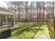 Lush backyard featuring a screened porch, a fenced yard with trees, and outdoor recreational equipment at 133 Caleb Ct, Ladson, SC 29456