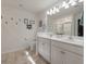 Well-lit bathroom with double vanity, framed mirrors, and decorative wall art at 133 Caleb Ct, Ladson, SC 29456