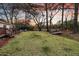 Lush backyard featuring a manicured lawn, wooden deck, fire pit, and mature trees at 1522 N Pinebark Ln, Charleston, SC 29407