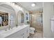 Bright bathroom with double vanity, tile flooring, and a glass-enclosed shower with decorative tile at 1522 N Pinebark Ln, Charleston, SC 29407