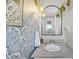 Stylish powder room features patterned wallpaper, unique light fixtures, and a granite countertop at 1522 N Pinebark Ln, Charleston, SC 29407