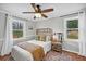 Bright bedroom showcasing two large windows, a wicker headboard, and a decorative area rug at 1522 N Pinebark Ln, Charleston, SC 29407