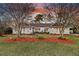 Charming brick home featuring landscaped yard with mature trees and colorful mulch at 1522 N Pinebark Ln, Charleston, SC 29407