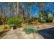 A concrete patio and outdoor green furniture provides a relaxing space in a wooded backyard at 202 Hunt Club Dr, Summerville, SC 29485
