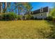 View of the home's backyard with lush lawn and landscaping and screened porch at 202 Hunt Club Dr, Summerville, SC 29485