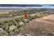 Aerial view of property nestled in trees with marsh views and a river in the distance at 212 Chinaberry Ln, Kiawah Island, SC 29455