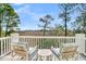 Relaxing balcony with marsh views, comfortable seating, and white railing at 212 Chinaberry Ln, Kiawah Island, SC 29455