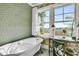 Relaxing bathroom with a clawfoot tub under bright windows offering tranquil views of the marsh at 212 Chinaberry Ln, Kiawah Island, SC 29455