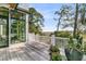 Deck with marsh views framed by trees and flowering plants with windows offering views to the interior at 212 Chinaberry Ln, Kiawah Island, SC 29455