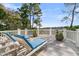 Relaxing deck features two chaise lounges with blue cushions, overlooking lush greenery and trees at 212 Chinaberry Ln, Kiawah Island, SC 29455