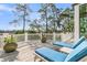 Relaxing deck features two chaise lounges with blue cushions, overlooking lush greenery and trees at 212 Chinaberry Ln, Kiawah Island, SC 29455