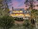 Stunning elevated home with multiple decks, lush landscaping, and beautiful sunset skies at 212 Chinaberry Ln, Kiawah Island, SC 29455