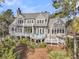 An exterior view of a house with gray shingles and trim, multiple decks, and surrounding trees at 212 Chinaberry Ln, Kiawah Island, SC 29455