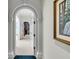Elegant hallway featuring arched doorways, plush carpeting, and a glimpse into an organized closet space at 212 Chinaberry Ln, Kiawah Island, SC 29455