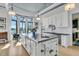 Bright kitchen with stainless steel island, white cabinets, and large windows overlooking the water at 212 Chinaberry Ln, Kiawah Island, SC 29455