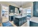 Elegant kitchen with blue cabinets, marble countertops, island, and open view to the dining area at 212 Chinaberry Ln, Kiawah Island, SC 29455