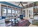 Sunlit living room boasts floor to ceiling windows and extensive built in bookshelves at 212 Chinaberry Ln, Kiawah Island, SC 29455