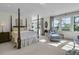 Bright and airy main bedroom with a four-poster bed, chaise lounge, and picturesque views from large windows at 212 Chinaberry Ln, Kiawah Island, SC 29455