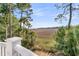 Picturesque marsh view from a charming deck with surrounding trees and sunny blue skies at 212 Chinaberry Ln, Kiawah Island, SC 29455