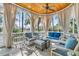 Bright sunroom boasts expansive windows, wood ceiling, and cozy seating arrangement at 212 Chinaberry Ln, Kiawah Island, SC 29455
