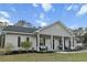 Charming home with a covered porch and manicured front lawn and mature landscaping at 218 Mohican Cir, Summerville, SC 29483