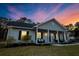 Inviting home with neutral siding, covered porch, outdoor seating and fresh landscaping at 218 Mohican Cir, Summerville, SC 29483