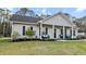 Charming home with a covered porch, black shutters, and a well-manicured lawn and landscaping at 218 Mohican Cir, Summerville, SC 29483