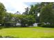 Spacious green backyard showing manicured lawn, auxiliary building and mature trees at 219 Rigby St, Reevesville, SC 29471