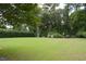 Spacious backyard featuring a well-maintained lawn, mature trees, and a peaceful seating area at 219 Rigby St, Reevesville, SC 29471