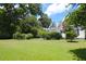 Expansive lawn area in the backyard, surrounded by mature trees and lush greenery, offering a private outdoor space at 219 Rigby St, Reevesville, SC 29471