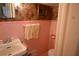 Vintage half-bathroom with pink tile, pink floral wallpaper and traditional fixtures at 219 Rigby St, Reevesville, SC 29471