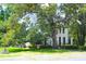 An eye-level exterior shot showing a white two-story home with black shutters and mature landscaping at 219 Rigby St, Reevesville, SC 29471